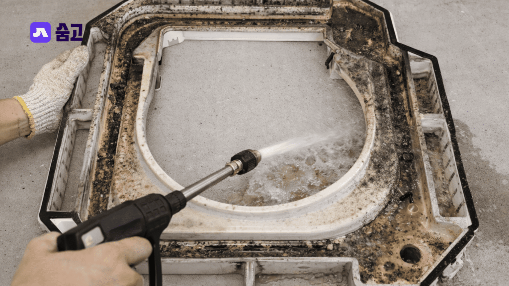 시스템 에어컨 청소 중 고압 세척기로 드레인판의 찌든 때를 제거하는 과정