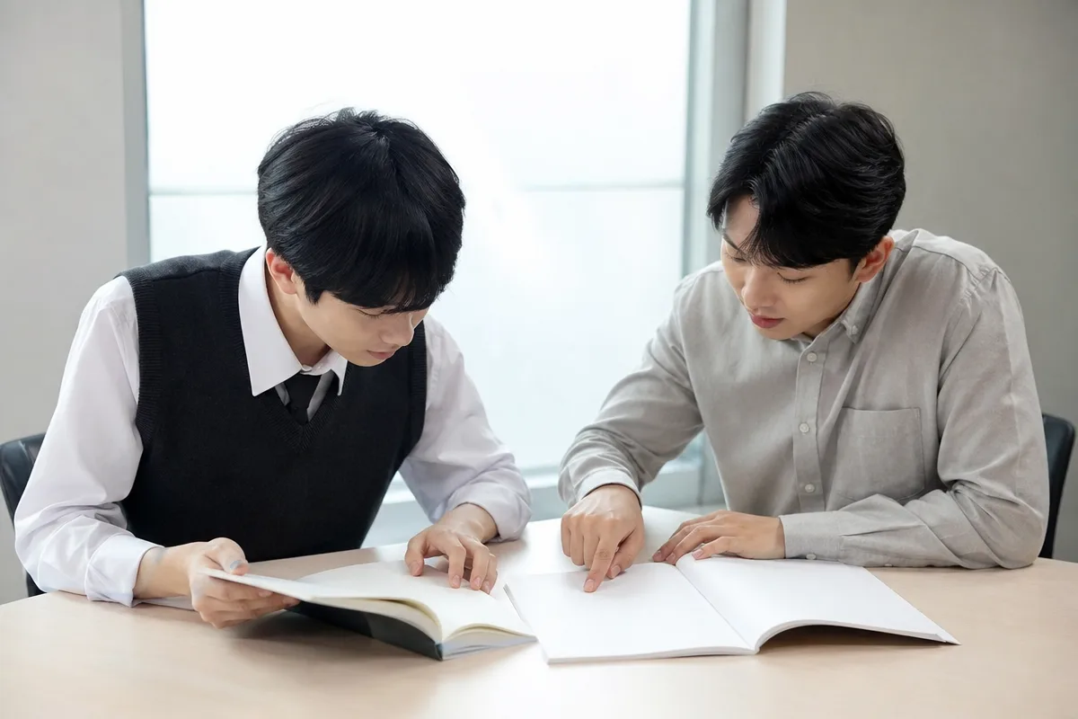 수학학원에서 학생과 강사가 내신과 수능 대비 학습 자료를 함께 검토하는 모습